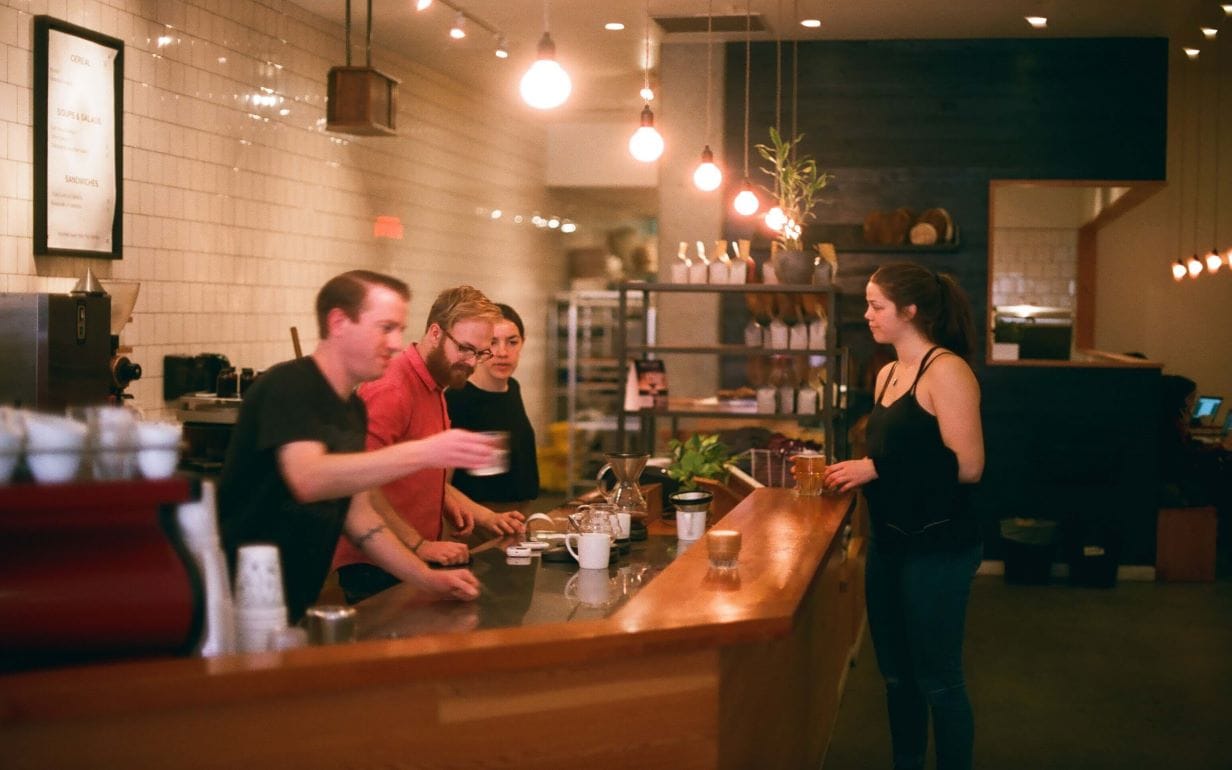 A woman paying for a drink at the cafe counter