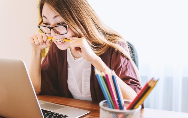 Young woman biting on a pencil